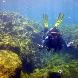 Snorkeler swimming through volcanic bubbles at Champagne Beach, one of the top Dominica beaches