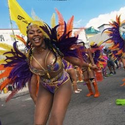 Colorful costumed performers dancing during Carnival in Dominica 2025